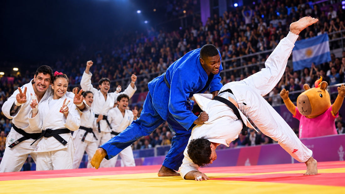 A judoka in blue throws an opponent in white as teammates celebrate beside the tatami, with an Argentina flag visible in the crowd.